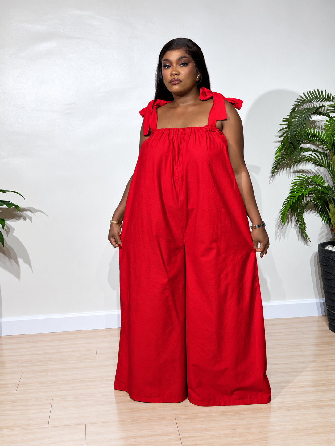 Solara jumpsuit with a gathered neckline, statement shoulder ties, and flowy wide-leg trousers, styled for effortless elegance.