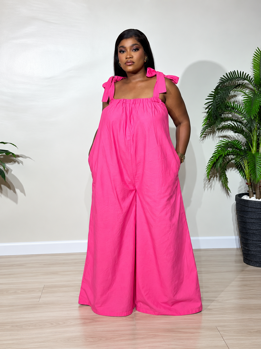 Solara jumpsuit with a gathered neckline, statement shoulder ties, and flowy wide-leg trousers, styled for effortless elegance.